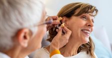 Doctor fitting a lady with a hearing device